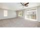 Bright bedroom with neutral carpet, ceiling fan, and sliding glass door to the outside at 1009 Ancient Timber Ave, Henderson, NV 89052