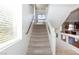 Carpeted stairs with white handrails lead to an open landing with a window and pendant lighting at 1009 Ancient Timber Ave, Henderson, NV 89052