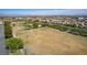 A wide aerial view shows a spacious open field with trees, surrounded by residential areas in the distance at 10216 Via Roma Pl, Las Vegas, NV 89144