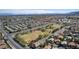 Expansive aerial view showcases a community with an open field, city skyline, and distant mountains at 10216 Via Roma Pl, Las Vegas, NV 89144