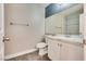 Bathroom featuring a toilet, sink, large mirror, and towel rack at 10216 Via Roma Pl, Las Vegas, NV 89144
