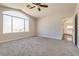 Spacious bedroom featuring a ceiling fan and a large arched window at 10216 Via Roma Pl, Las Vegas, NV 89144