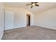 Bedroom with neutral walls, ceiling fan, and an open closet for easy organization at 10216 Via Roma Pl, Las Vegas, NV 89144