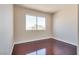 Cozy bedroom with wood flooring and a bright window offering outdoor views at 10216 Via Roma Pl, Las Vegas, NV 89144