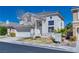 Inviting two-story home with a manicured lawn, a two-car garage, and nearby palm trees at 10216 Via Roma Pl, Las Vegas, NV 89144