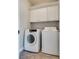 Bright laundry room featuring a washer and dryer plus white cabinets for storage at 10216 Via Roma Pl, Las Vegas, NV 89144