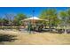 Neighborhood playground featuring a covered play structure, benches, and surrounding grassy area at 10216 Via Roma Pl, Las Vegas, NV 89144