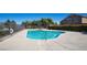 Community pool with cool, clear water surrounded by a concrete deck and mature landscaping at 10216 Via Roma Pl, Las Vegas, NV 89144