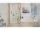 Bright bathroom featuring a glass-enclosed shower and a soaking tub under a window at 1328 Graphite Ave, Henderson, NV 89002