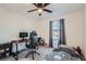 Bedroom with a dark wood desk, monitor, and ceiling fan providing functionality and comfort at 1328 Graphite Ave, Henderson, NV 89002