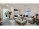 Bright living room features a stylish gray sectional sofa, a marble coffee table, and light gray carpet at 1328 Graphite Ave, Henderson, NV 89002