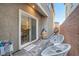 Cozy outdoor patio area with modern white furniture, a 'Welcome' mat, and brick wall surround at 1328 Graphite Ave, Henderson, NV 89002