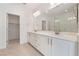 Elegant bathroom featuring dual sinks, white cabinetry, and walk-in shower access at 1785 Flycatch St, Las Vegas, NV 89138