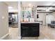 Wet bar featuring glass shelving, granite counters, and dark cabinetry that leads into the kitchen at 2673 Red Rock St # 102, Las Vegas, NV 89146