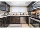 Efficient kitchen layout with dark wood cabinets, stainless steel appliances, and a bright window at 2673 Red Rock St # 102, Las Vegas, NV 89146