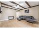 Cozy living room featuring beamed ceiling, tile floors, and a comfortable gray sectional sofa at 2673 Red Rock St # 102, Las Vegas, NV 89146