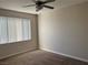 A carpeted bedroom with neutral colors, a ceiling fan, and natural light from the window at 2900 Sunridge Heights Pkwy # 327, Henderson, NV 89052