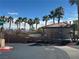 Community pool area surrounded by palm trees and lush landscaping on a sunny day at 3920 Legend Hills St # 204, Las Vegas, NV 89129