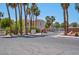 Entry to the Laguna Del Rey community featuring mature palms, lush vegetation and a security gate at 5000 Red Rock St # 241, Las Vegas, NV 89118
