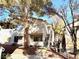 Exterior view of a two-story home surrounded by mature trees and well-kept landscaping at 5222 Mandalay Springs Dr # 202, Las Vegas, NV 89120