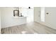 Bright living room features white walls, wood-look floors, and access to the kitchen and front door at 5222 Mandalay Springs Dr # 202, Las Vegas, NV 89120