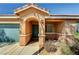 Inviting front entrance featuring an arched entryway, low maintenance landscaping, and a two-car garage at 5292 Cholla Cactus Ave, Las Vegas, NV 89141
