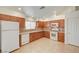 Bright kitchen featuring wood cabinetry, white appliances, tile countertops, and an open layout at 5292 Cholla Cactus Ave, Las Vegas, NV 89141