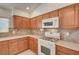Charming kitchen with wood cabinets, tile backsplash, modern appliances, and natural light streaming in at 5292 Cholla Cactus Ave, Las Vegas, NV 89141