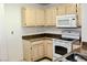 A kitchen featuring tan cabinets, a white range, and an over-the-range microwave at 555 E Silverado Ranch Blvd # 2005, Las Vegas, NV 89183