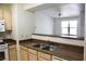 A kitchen featuring a double sink, light wood cabinets, and pass-through to the living area at 555 E Silverado Ranch Blvd # 2005, Las Vegas, NV 89183