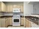 A kitchen featuring tan cabinets, a white range, and an over-the-range microwave at 555 E Silverado Ranch Blvd # 2005, Las Vegas, NV 89183
