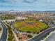 Aerial view of a baseball field in a community surrounded by parked cars and roadways at 6 Desert Dawn Ln, Henderson, NV 89074
