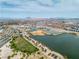 Wide aerial shot reveals a community lake, park, and residential development with mountain views at 6 Desert Dawn Ln, Henderson, NV 89074