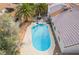 Aerial view showcases a kidney-shaped backyard swimming pool surrounded by lush palm trees and patio furniture for outdoor entertaining at 6320 Vicuna Dr, Las Vegas, NV 89146