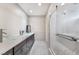 Bathroom featuring double vessel sinks, dark cabinets, and a modern walk-in shower at 6320 Vicuna Dr, Las Vegas, NV 89146