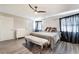 Cozy bedroom with soft gray walls, wood floors, ceiling fan, and a comfortable bed with decorative pillows at 6320 Vicuna Dr, Las Vegas, NV 89146