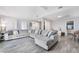 Bright living room with large sectional sofa and wood-look tile flooring at 6320 Vicuna Dr, Las Vegas, NV 89146