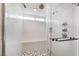 Modern shower with white textured tile, a built-in bench, and a sleek glass door at 6320 Vicuna Dr, Las Vegas, NV 89146