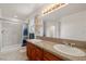 Bathroom featuring double sinks, granite counters, tiled shower, and window at 672 Lampshire Ln, Pahrump, NV 89060