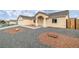 Landscaped front yard featuring rock accents and a charming entrance with an archway and pillars at 672 Lampshire Ln, Pahrump, NV 89060