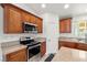Kitchen featuring stainless steel appliances, wooden cabinets, and granite countertops at 672 Lampshire Ln, Pahrump, NV 89060