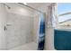Shower with marble-look tiling, showerhead, and window at 672 Lampshire Ln, Pahrump, NV 89060