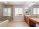 Sunlit bathroom featuring a glass shower, double vanity, and large window with shutters at 872 Timber Walk Dr, Henderson, NV 89052