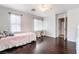 Airy bedroom with hardwood floors, a ceiling fan, and two large windows at 872 Timber Walk Dr, Henderson, NV 89052