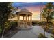 Picturesque community gazebo with elegant columns, lush landscaping, and stunning mountain views at sunset at 872 Timber Walk Dr, Henderson, NV 89052