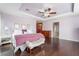 Bright and airy primary bedroom boasts wood floors, tray ceiling, and a cozy sitting area at 872 Timber Walk Dr, Henderson, NV 89052