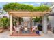 Relaxing patio with seating area, water feature, and lush greenery-covered pergola at 872 Timber Walk Dr, Henderson, NV 89052