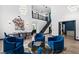 Bright living room features high ceilings, staircase, modern lighting and comfortable blue velvet seating area with a chess table at 9417 Churchill Downs Dr, Las Vegas, NV 89117