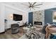 Cozy living room features a large television, modern fireplace, and comfortable seating area with modern fan and lighting at 9417 Churchill Downs Dr, Las Vegas, NV 89117