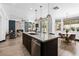Spacious area with tiled floors, a kitchen island, a fireplace, modern lights, and backyard access at 9417 Churchill Downs Dr, Las Vegas, NV 89117
